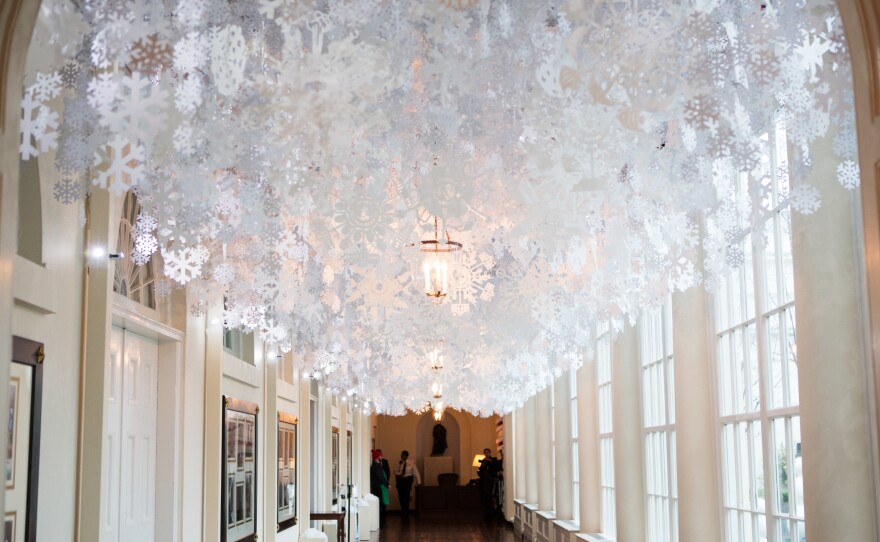 Hand-cut paper snowflakes line the ceiling of the East Colonnade. The White House is expecting over 60,000 visitors this holiday season.