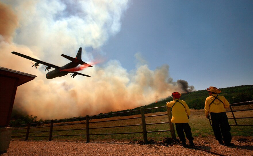 Emergency crews drop a fire retardant slurry on a running wildfire to save a house on April in Strawn, Texas, on Tuesday.
