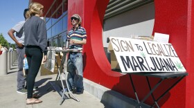Petition signature gatherer Peter Keyes, right, discusses a petition to legalize marijuana, in Sacramento, April 23, 2016.