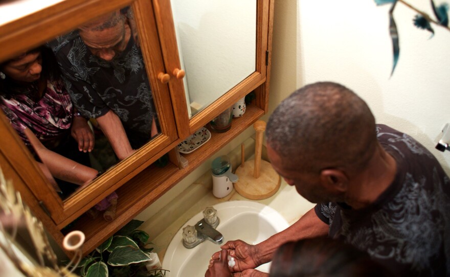 Loretta Jackson shows her father, Theodis Turner, how to wash his hands. Theodis has dementia and lives with the Jacksons.