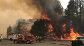 In this photo provided by the Cal Fire Communications, firefighters battle a wildfire in an area northeast of Clearlake Oaks, Calif., Sunday, June 24, 2018.