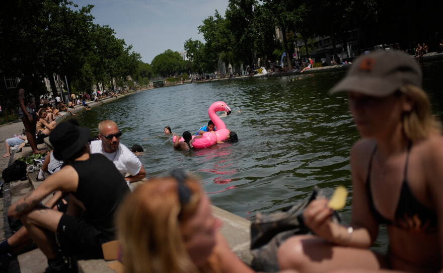 Parisians bath in the Canal Saint-Martin in Paris, as the national weather service, Meteo France, placed 54 departments, about half the country, under a red heat wave alert, Tuesday, June 23, 2026.