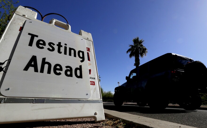 A vehicle arrives at COVID-19 testing site at Steele Indian School Park on May 23 in Phoenix. Arizona has seen a rush of new coronavirus cases recently.