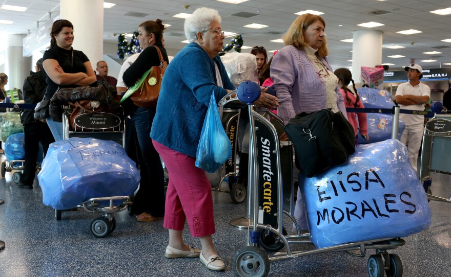 Travelers wait to check in for charter flights from Miami to Havana at Miami International Airport.