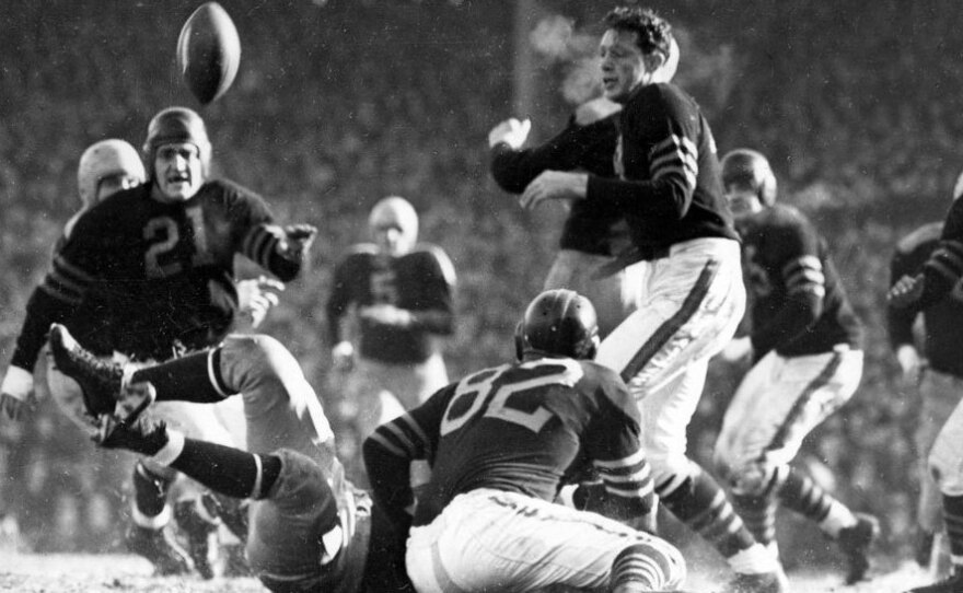 In the 1941 Western Division playoff game at Wrigley Field, Chicago Bears guard Danny Fortmann (21) gets a bead on the ball jarred loose by Bears guard Ray Bray (82).