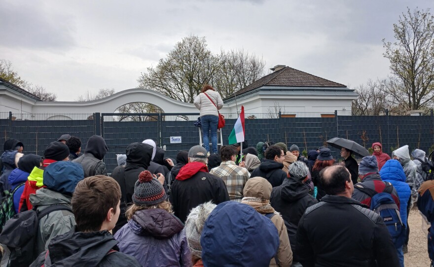Sightseers climb a ladder to see onto the grounds of Viktor Orbán's family's estate.