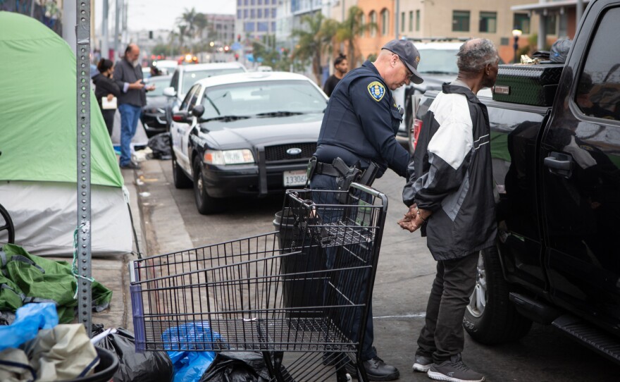 A San Diego police officer arrests a person during an enforcement sweep of sidewalks on Commercial Street in San Diego, June 9, 2022.  