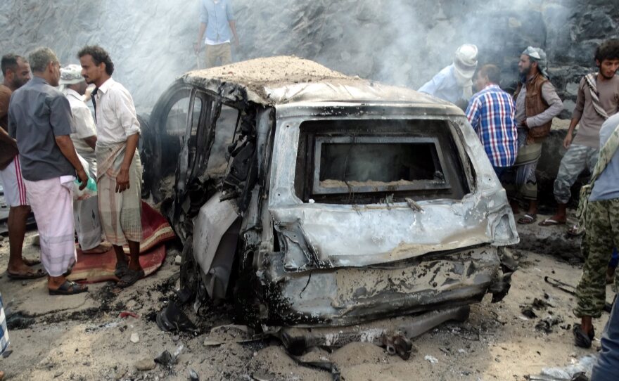 Yemenis inspect the scene of a car bomb attack that killed a Yemeni senior official in the southern port city of Aden, Yemen, on Sunday.
