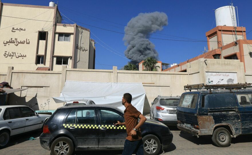 People watch as smoke and dust ascend following Israeli bombardment, in Khan Yunis in the southern Gaza Strip, on Thursday.