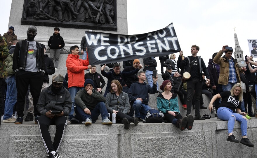 People without face masks attend a protest against government restrictions to curb the spread of the coronavirus in London on Saturday.