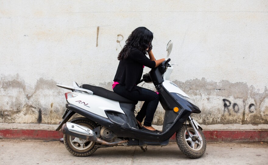 Dalila, from La Democracia, Guatemala, sits on a motorcycle in a small town near the border with Mexico. She plans to leave later this month for the United States with her 5-year-old daughter.