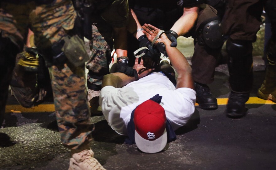 Police arrest a demonstrator protesting the killing of teenager Michael Brown in Ferguson, Mo.