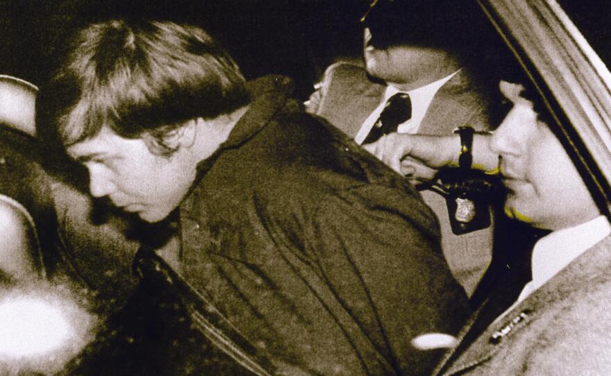 John Hinckley Jr. is escorted by police in Washington, D.C., following his arrest after shooting and seriously wounding president Ronald Reagan on March 30, 1981.