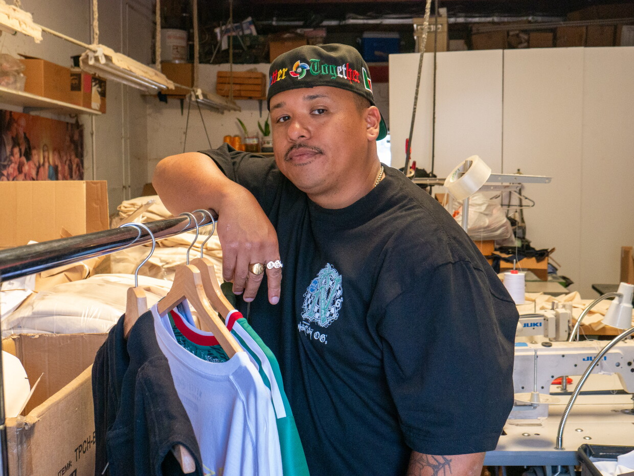 Moss Randy Ortega leans against a clothing rack for a portrait at Norma's Apparel in National City on Aug. 3, 2026.