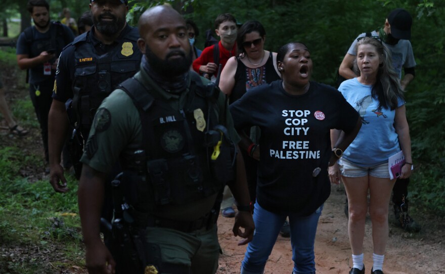 Rev. Keyanna Jones, an organizer with Community Movement Builders and the Faith Coalition to Stop Cop City, sings civil rights era songs at a gathering in opposition to the Atlanta Public Safety Training Center that protesters refer to as "Cop City," as law enforcement marched through Brownwood Park just as a vigil for killed activist Manuel "Tortuguita" Terán was set to begin.