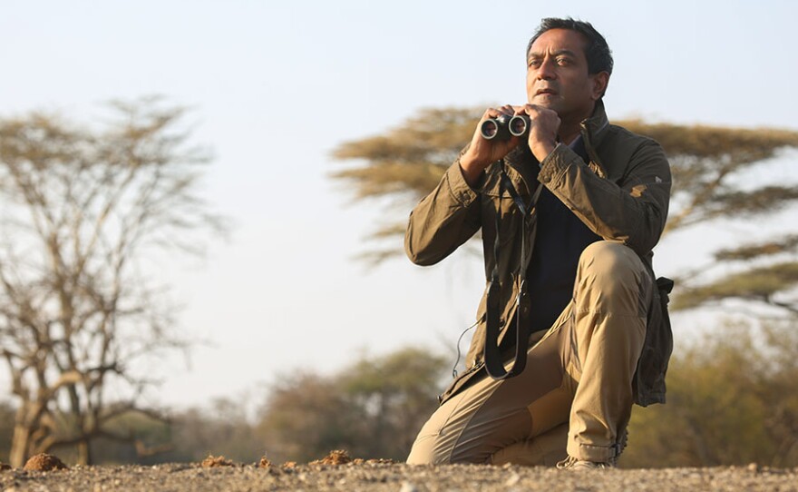 M. Sanjayan doing a spot of wildlife watching around the waterhole. Tanzania, Africa.