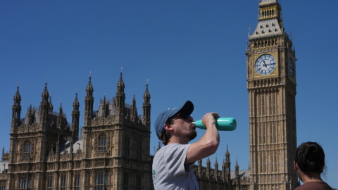 A man drinks Tuesday outside the Palace of Westminster in London.