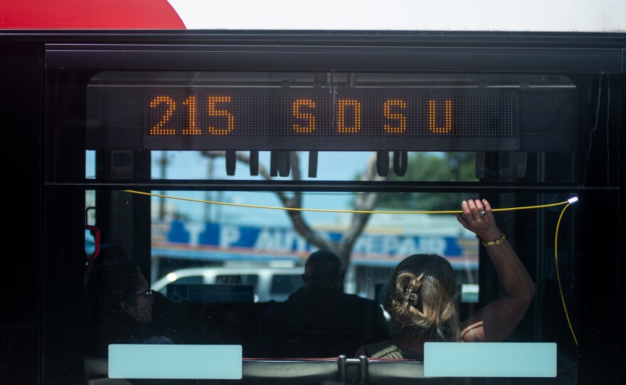 A bus rider prepares for a stop on the Mid-City Rapid 215 route on El Cajon Boulevard in San Diego on April 26, 2019.