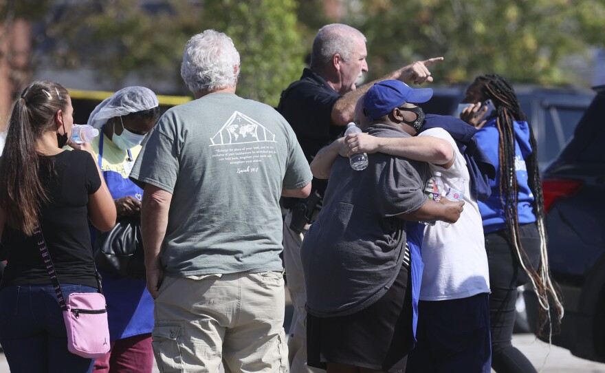 People embrace as police respond to the scene of a shooting at a Kroger's grocery store in Collierville, Tenn., on Thursday, Sept. 23, 2021.