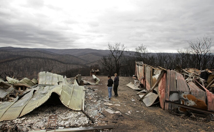 People inspect their house in the aftermath of the bushfires in Steels Creek, just south of Kinglake.