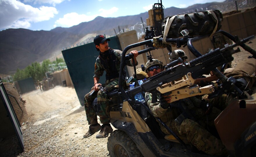 An Afghan soldier rides on the back of a U.S. Green Beret vehicle near the village of Kasan, west of Kabul, in 2013. American combat forces will leave by year's end, but it's not clear how the Afghan forces will handle the Taliban threat.