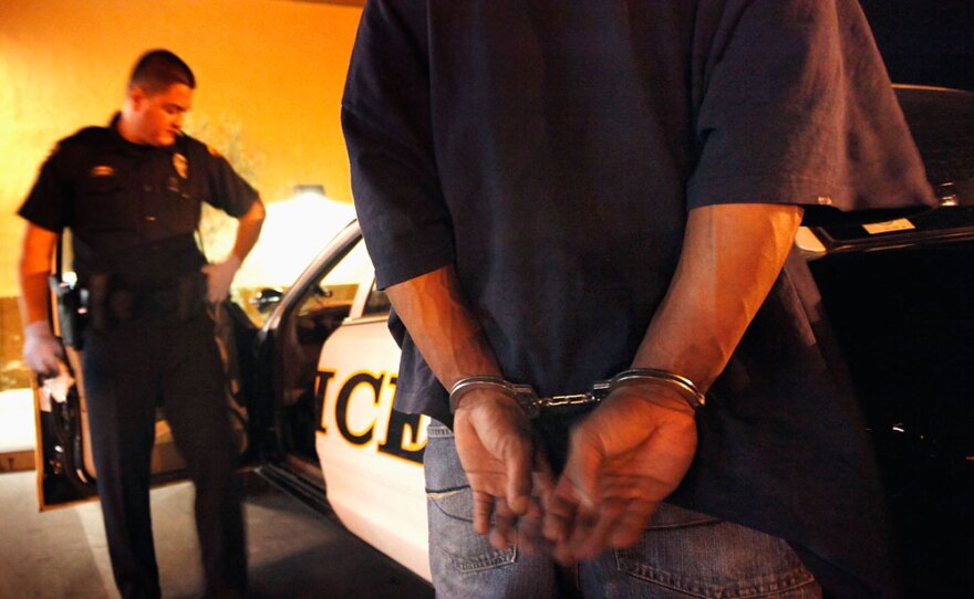 Tucson Police officer Angel Ramirez and a man suspected of trespassing, in May. While many law enforcement officials support the new Arizona immigration law, others worry it will hurt relations with the community.