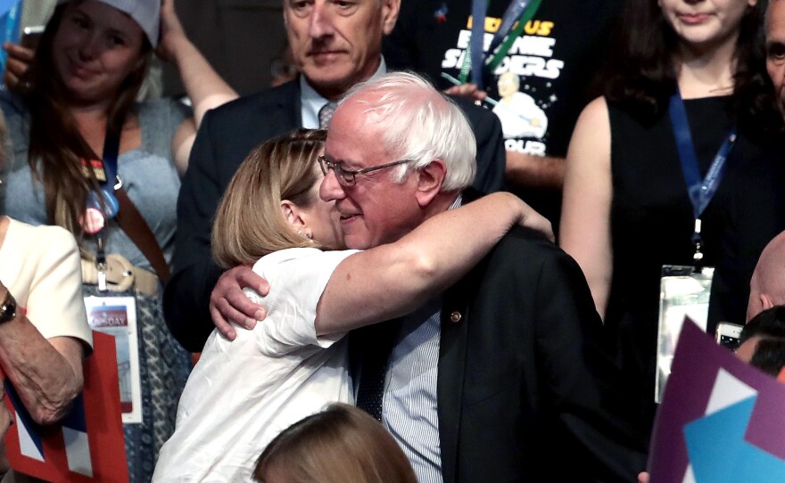 Sen. Bernie Sanders hugs an attendee during roll call on the second day of the Democratic National Convention.