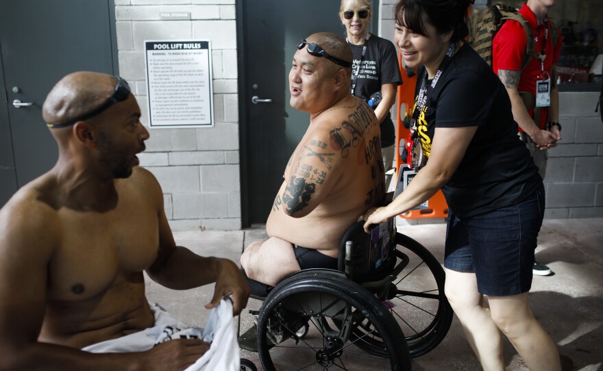 Alicia and Matt Lammers talk to his teammate Brent Garlic after competing at the 2019 Department of Defense Warrior Games.