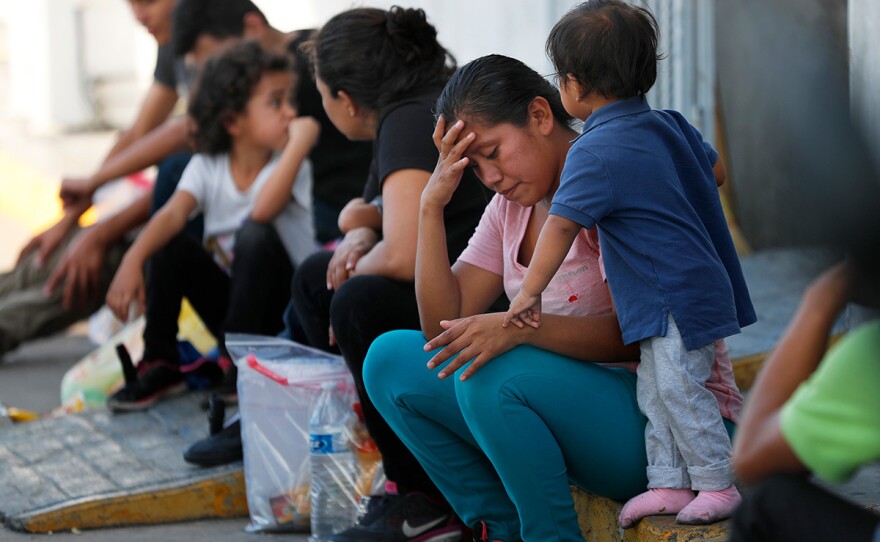 In this July 16, 2019, file photo, migrants wait at an immigration center on the International Bridge 1, in Nuevo Laredo, Mexico.