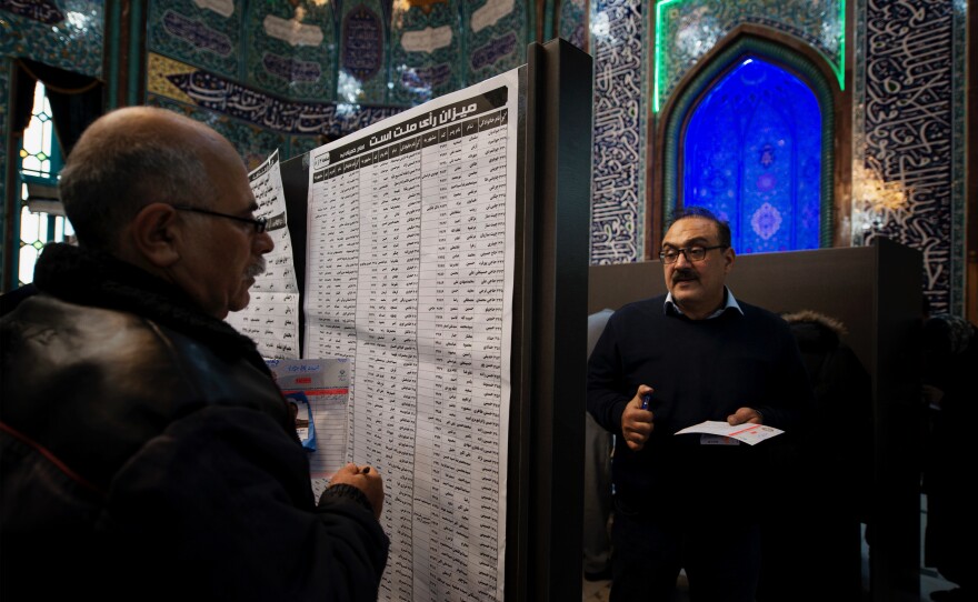 The lists of candidates are placed on a board in the middle of Hoseyniye Ershad, one of the main voting locations in Tehran. More than 7,000 candidates are hoping to win spots in Iran's 290-seat parliament.