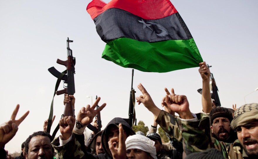 Libyan rebels fly a flag from the days before Gadhafi rule as they celebrate the capture of Ras Lanuf in eastern Libya on Saturday.