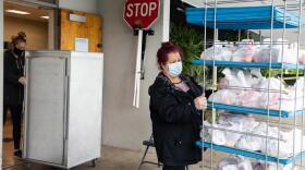 Guadalupe Cortez, right, brings out meals to distribute to families at Las Palmas Elementary School in National City, April 10, 2020.