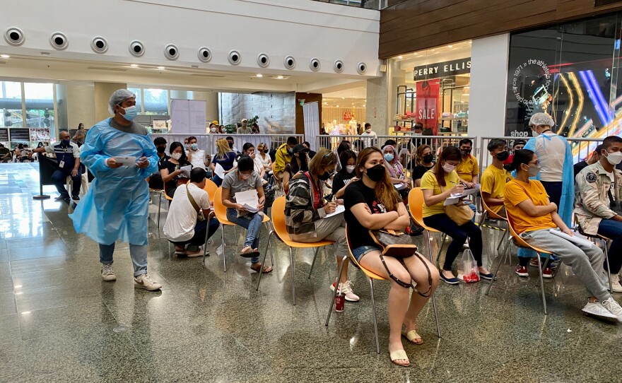 Crowds turned out to receive vaccines at an upscale shopping mall in metro Manila. Because the mall draws large numbers of holiday shoppers, it was considered a strategic choice for a vaccine site.