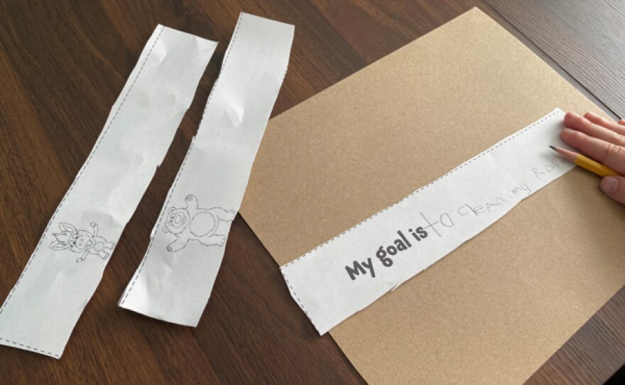 A child arranges goal strips on cardboard in this undated photo.