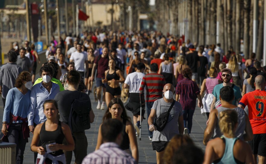 Crowds of people took to a seafront promenade under a brilliant sunny sky in Barcelona, where Spain's strict coronavirus lockdown measures were lifted Saturday so that adults could get some exercise.