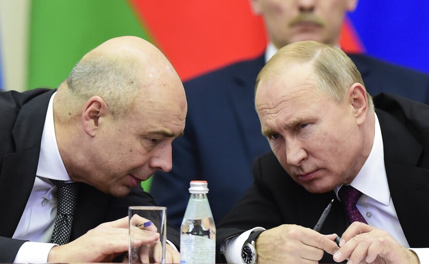 Russian President Vladimir Putin and Finance Minister Anton Siluanov chat during a meeting of the Supreme Eurasian Economic Council in Saint Petersburg, Russia, on Dec. 6, 2018. Russia's Finance Ministry is threatening to sue, saying sanctions from the U.S. and its allies are preventing the country from making interest payments in dollars to foreign investors.