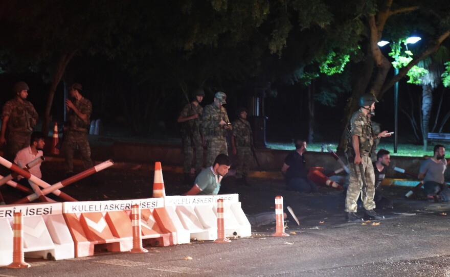 Turkish security officers detain unidentified individuals on the side of the road on Friday in Istanbul, during a shutdown of the Bosporus bridge.