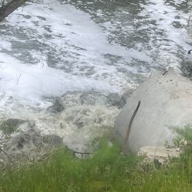 Wastewater flows out of pipe and polluted foam clouds float on top of the Tijuana River in the Nestor neighborhood of San Diego, California on April 16, 2025.