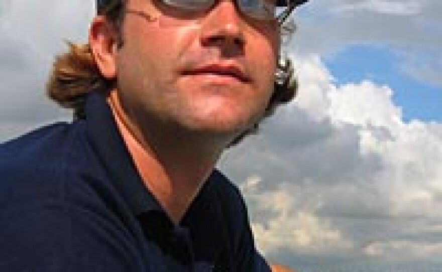 Zeb Hogan, pictured here traveling on the Tonle Sap River, is a National Geographic Society Emerging Explorer leading a project to identify and protect the world's largest freshwater fishes.