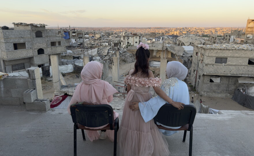 Three sisters sit looking out over a sea of debris as the sun sets in northern Gaza's militarized orange zone of Beit Lahia, on May 31.