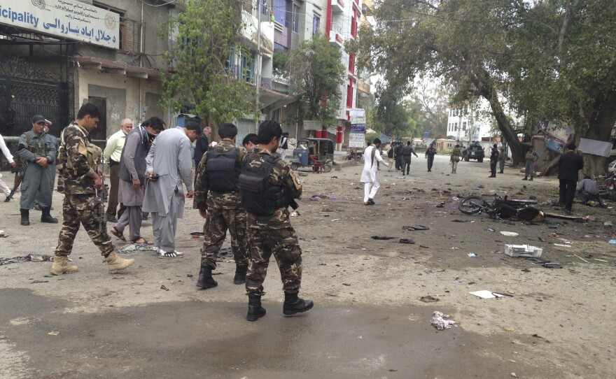 Afghan security forced inspect the site of a suicide attack near a New Kabul Bank in Jalalabad in eastern Afghanistan Saturday. The United Nations says at least 35 people died.