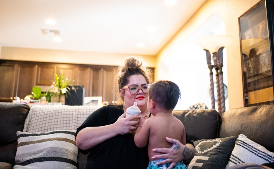 Johnson gives River a bottle in her home in Discovery Bay. Family members spent isolation together there this summer, after getting sick with COVID-19. Everyone has since recovered.