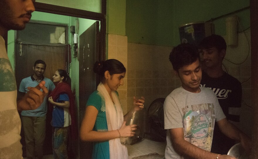 Saumil and Zarina Shah (background) help do chores with other newlywed couples at a Love Commandos safe house in New Delhi.