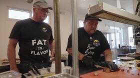 Blake Barrow works with an employee at Hallelujah! BBQ.