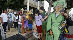 Members a coalition of Latino groups hold posters of immigrant workers and Dream Act students as they join a pro-immigrant rally outside the Federal Building in Los Angeles, March. 26, 2014. 