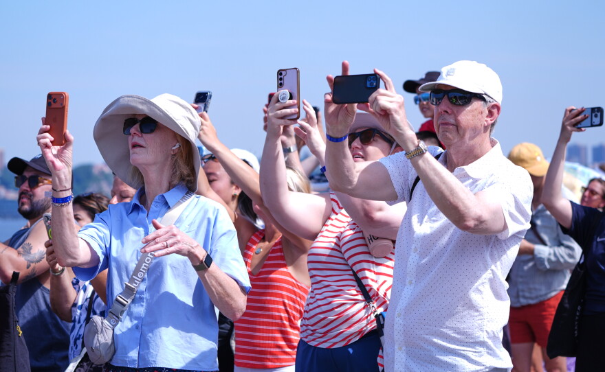 People watch as the French Air Force acrobatic squad Patrouille de France perform a flyover during the International Aerial Review on Saturday in New York.