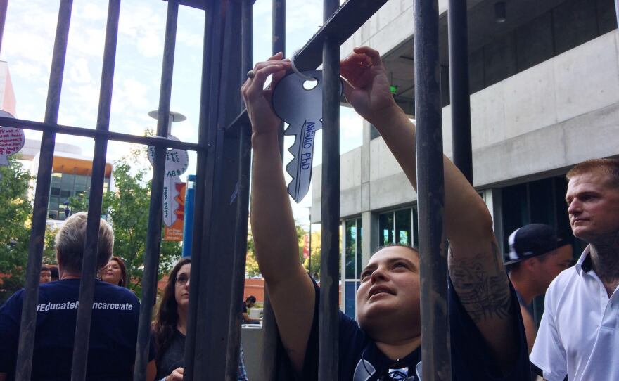 Nora Angulo fastens a key that reads "Angulo PhD" to a faux jail cell at San Diego City College, Sept. 11, 2017.