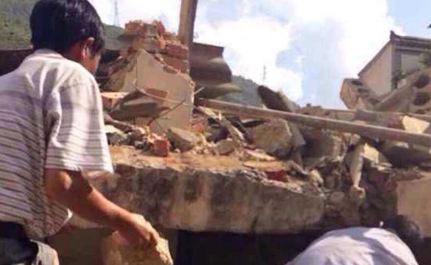 Residents look for survivors in the rubble of a collapsed house after a 6.1-magnitude earthquake hit the area in Ludian county in Zhaotong, southwest China's Yunnan province Sunday. The quake hit at a relatively shallow depth of about 6 miles.