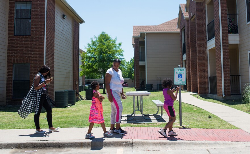 C'Artis Harris, walking with her children in 2017, was searching for housing that would accept her Section 8 voucher when NPR began following her in 2016. Today, Harris and her family still live in an area of high poverty.