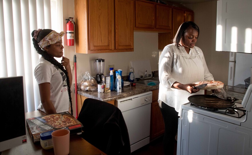 Maryanne Lundy, (right) prepares a pizza while talking with her daughter, Malaysia Hill, at their home on Friday, Nov. 19 in Indianapolis.